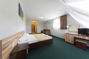 a hotel room with a bed and a flat screen tv at Hotel Restaurant Vizit in Truskavets
