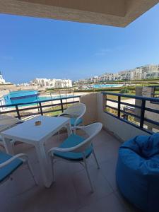 a balcony with tables and chairs and a view of the ocean at Remas resort in El Alamein