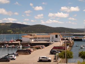 a marina with cars parked next to the water at Ave del Mar in Camariñas
