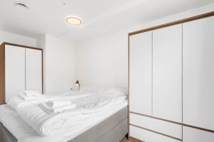 a bedroom with a large white bed with a mirror at Helt ny leilighet in Leknes