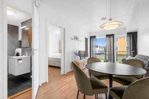 a living room with a table and chairs and a bedroom at Helt ny leilighet in Leknes