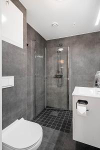 a bathroom with a shower and a toilet and a sink at Helt ny leilighet in Leknes +7 photos