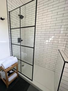 a bathroom with a glass shower with a stool at Cabin Oasis near Town in Catskill