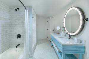 a bathroom with a blue sink and a mirror at The Beacon at Embassy Row, WorldHotels Distinctive in Washington, D.C. +35 photos