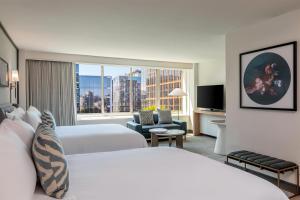 a hotel room with two beds and a large window at The Beacon at Embassy Row, WorldHotels Distinctive in Washington, D.C.