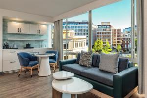 a living room with a couch and a large window at The Beacon at Embassy Row, WorldHotels Distinctive in Washington, D.C.