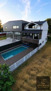 a large house with a swimming pool in front of it at Belgrade River House in Belgrade