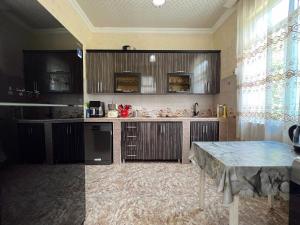 a kitchen with wooden cabinets and a table in it at Resort In Gonio in Kvariati