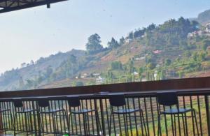 a balcony with chairs and a view of a mountain at At Venue Groups in Kodaikānāl +46 photos
