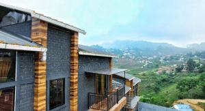 a house with a balcony on the side of it at At Venue Groups in Kodaikānāl