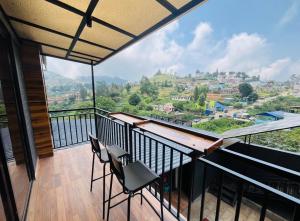 a balcony with chairs and a view of a mountain at At Venue Groups in Kodaikānāl