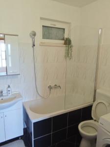 a bathroom with a tub and a toilet and a sink at Apartman Daniela in Neum