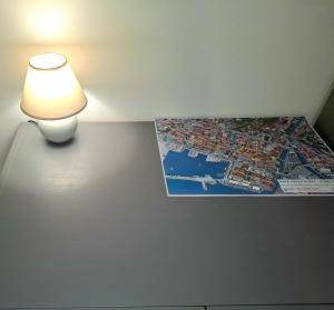 a lamp on a table with a map on the wall at C&M Studio Apartment in Rijeka +2 photos