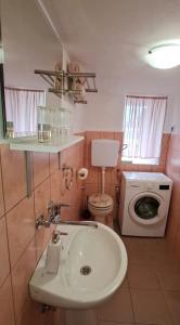 a bathroom with a sink and a washing machine at C&M Studio Apartment in Rijeka