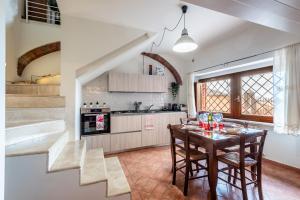 a kitchen with a table and chairs and a kitchen with a staircase at Appartamento BePlace - Subborgo in Rapolano Terme
