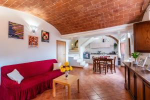 a living room with a red couch and a kitchen at Appartamento BePlace - Subborgo in Rapolano Terme +13 photos