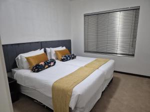 a bedroom with a bed with pillows and a window at Elegant Bliss -2 bedroomed at Dainfern, in Fourways, Sandton in Fourways