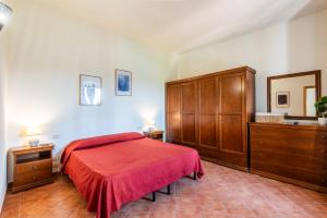 a bedroom with a red bed and wooden cabinets at Appartamento BePlace - Subborgo in Rapolano Terme