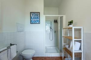 a white bathroom with a toilet and a shower at Appartamento BePlace - Subborgo in Rapolano Terme