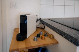 a black and white appliance sitting on a wooden shelf at Gemütliches Studio im Stadtzentrum in Biel +10 photos