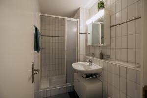 a white bathroom with a sink and a shower at Gemütliches Studio im Stadtzentrum in Biel