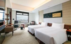 a hotel room with two beds and a desk at InterContinental Foshan by IHG in Foshan