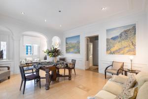 a dining room and living room with a table and chairs at Can Lluís in Capellades