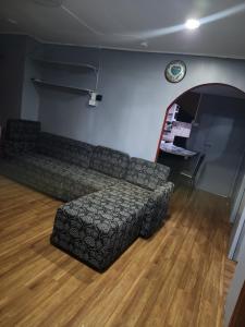 a living room with a couch and a clock on the wall at Aaqib Homestay in Suva