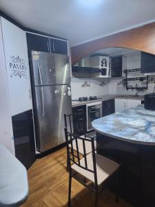 a kitchen with a refrigerator and a table with chairs at Aaqib Homestay in Suva