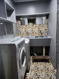 a small kitchen with a sink and a washing machine at Aaqib Homestay in Suva