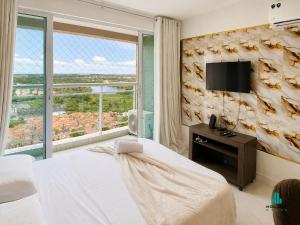 a bedroom with a bed and a tv on a wall at Fortaleza Sul by Holiday Stays in Fortaleza