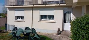 two chairs and a table in front of a house at gite victoria in La Pommeraie-sur-Sèvre