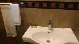 a bathroom with a white sink and a towel at The Ivy Hotel in Lusaka