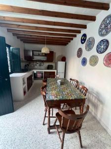 a kitchen with a table and chairs and plates on the wall at Villa Zina s3 in El Mây