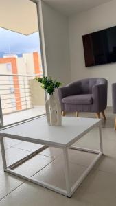 a white coffee table with a vase on it in a living room at Apartamento Vergel in Ibagué