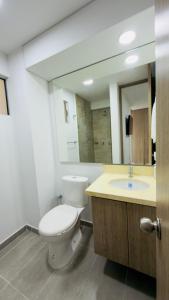 a bathroom with a toilet and a sink and a mirror at Apartamento Vergel in Ibagué +10 photos