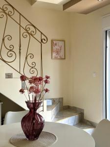 a vase with flowers sitting on a table at Malama Rooms in Paralia Katerinis