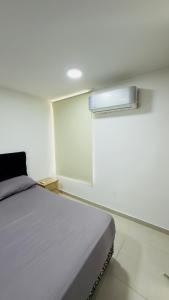 a bedroom with a white bed and a window at Apartamento Vergel in Ibagué
