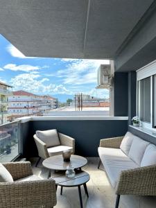 a living room with two couches and a table at Malama Rooms in Paralia Katerinis