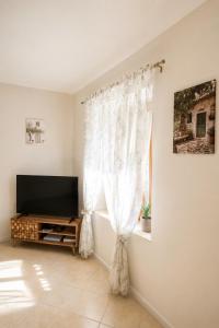 a living room with a tv and a window at Daisy House Golden Beach Area in Potamiá