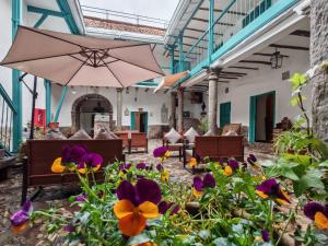 a patio with flowers and an umbrella at Afma Nueva Alta in Cusco