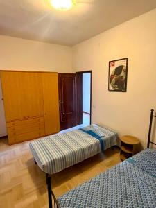 a bedroom with two beds and a cabinet in it at Motor Rooms in Maranello