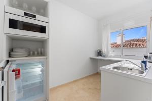 a white kitchen with a sink and a window at Edf España Suites Mijas in Mijas