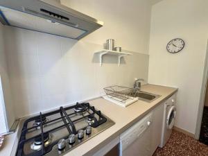 a kitchen with a stove and a sink and a clock at Villa Lilly in Grado