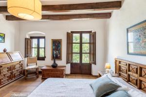 a bedroom with a bed and a desk and windows at Apartamento II Els Cucons in Sant Pere de Ribes +28 photos