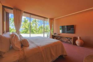 a bedroom with a large bed and a large window at Origem Patacho Design Hotel in Pôrto de Pedras
