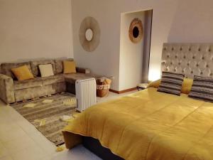 a bedroom with a large bed and a couch at Garça-Real 1 in Vale de Madeiros