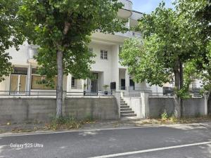a white building with trees in front of a street at Garça-Real 1 in Vale de Madeiros