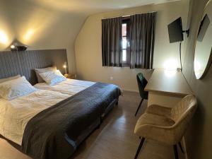 ein Schlafzimmer mit einem Bett, einem Schreibtisch und einem Stuhl in der Unterkunft Hotel De Villa in Zelzate
