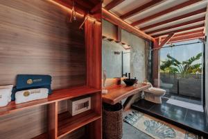 a bathroom with a toilet and a wooden wall at Jaguar Beachfront Ecohotel & Spa in Santa Marta